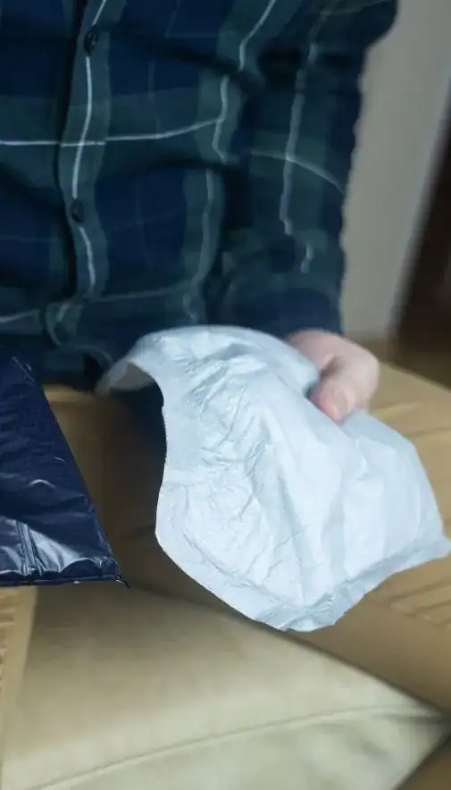 Image of man holding incontinence pads as part of overactive bladder treatment Swansea